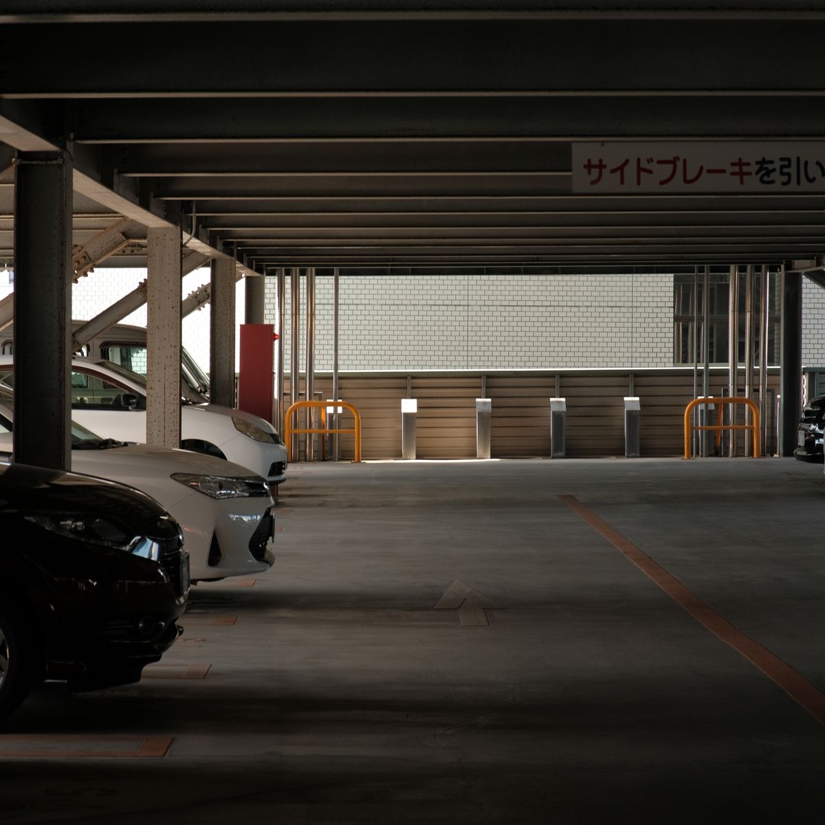 駐車場に長期間停められた車。乗らない期間とバッテリー上がりの解説