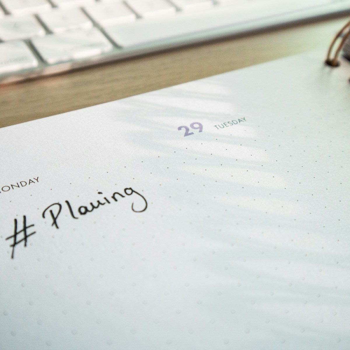 キーボードの前に置かれた、Planningと書かれた手帳(計画づくりのイメージ)